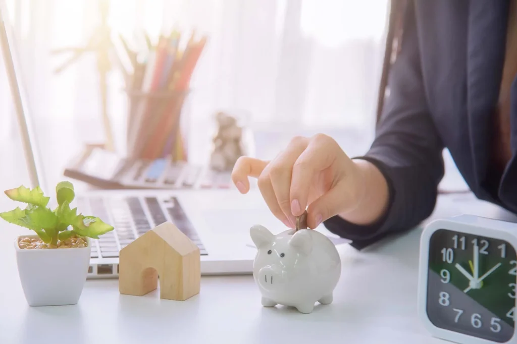 Why you should top up your ISA before the tax year end? 1 A woman adding money to a piggy bank
